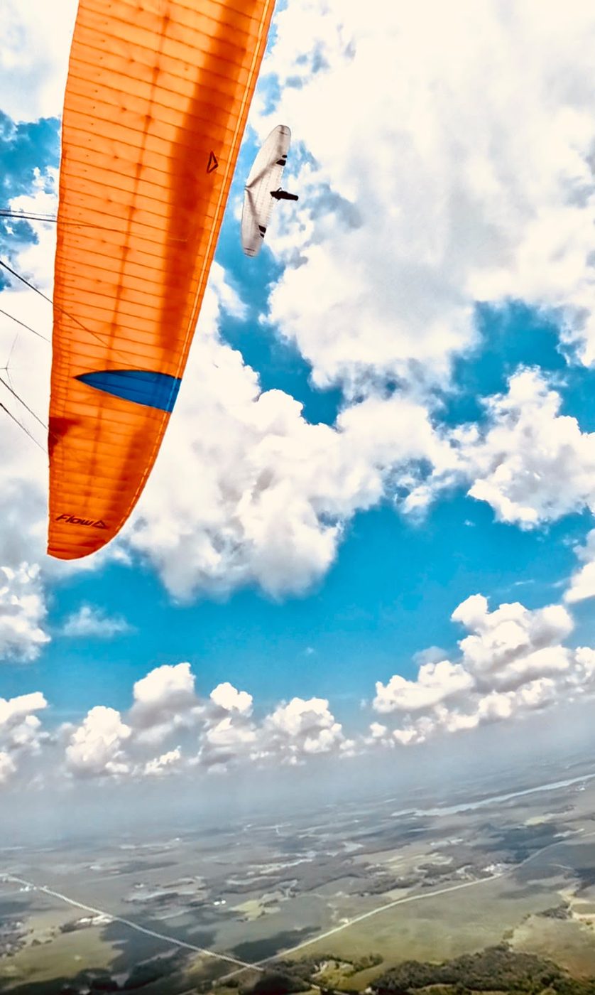 A paraglider and hang glider sharing a thermal together