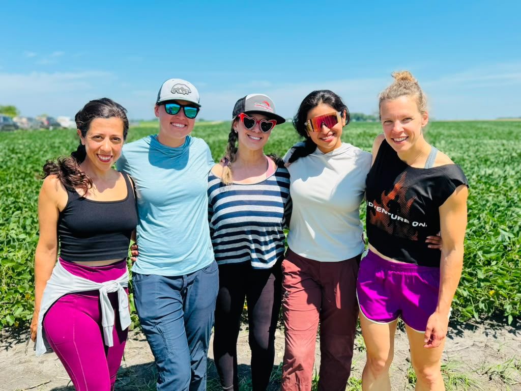 Five women pilots smiling together in the field