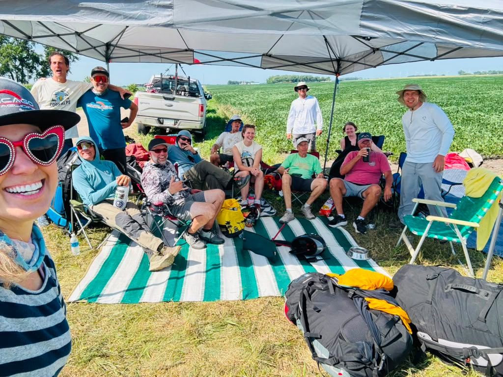 The full crew gathered under the shade tent