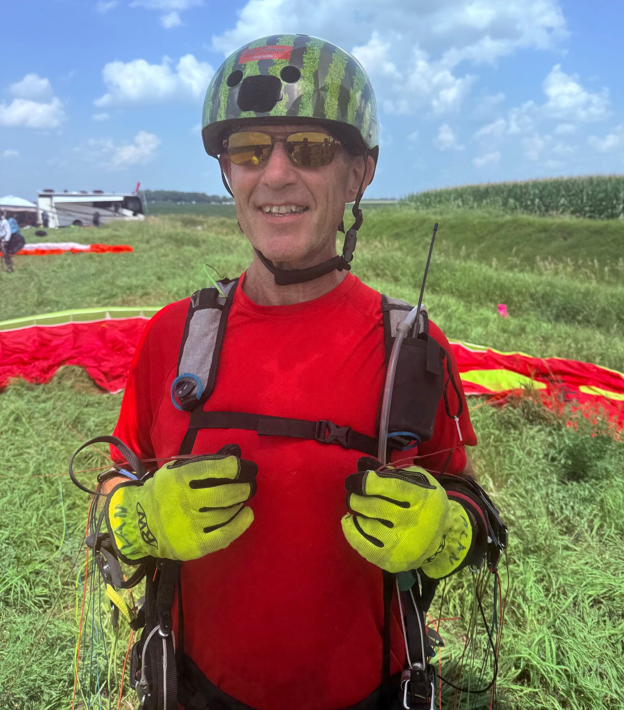 A pilot in a watermelon-patterned helmet giving a thumbs up